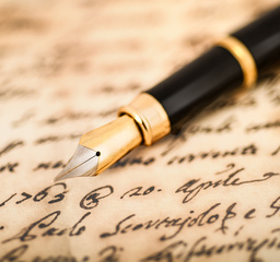 An brown parchment adorned with elegant handwriting, accompanied by a beautiful fountain pen resting atop it.