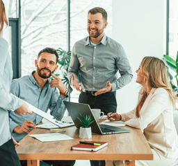 A team gathered around a table, engaging in an enthusiastic discussion.