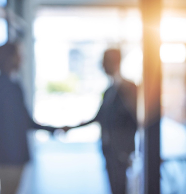 Unfocused shot of two businessmen shaking hands in an office.