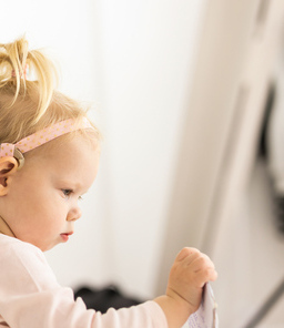 Very young child with a Cochlear implant playing.