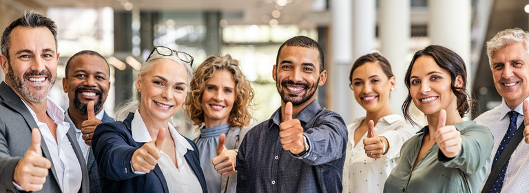 Group of people with friendly faces giving a thumps up gesture.