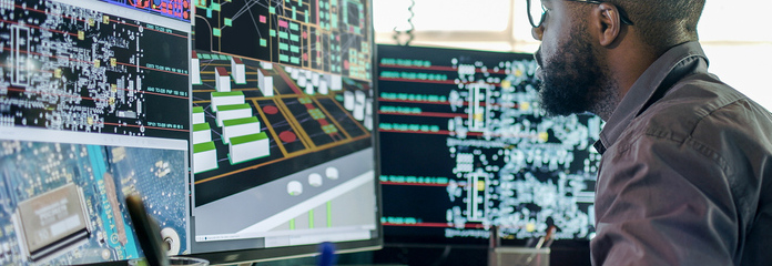 An engineer working on a PCB design at a computer.