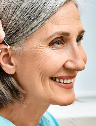 Woman wit behind the ear hearing aid.