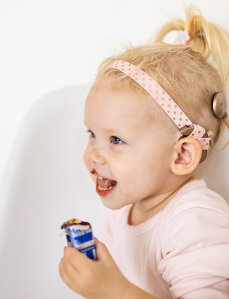 Happy young child with Cochlear implant.