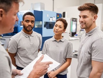 An expert teaching a group of employees on proper operational procedures.